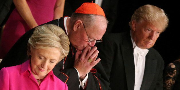 (L-R) Democratic U.S. presidential nominee Hillary Clinton, Archbishop of New York Cardinal Timothy Dolan and Republican U.S. presidential nominee Donald Trump pray as they attend the Alfred E. Smith Memorial Foundation dinner to benefit Catholic charities in New York, U.S., October 20, 2016. REUTERS/Carlos Barr