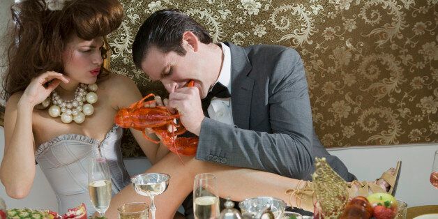 Portrait of couple indulging in lobster at elegant dinner party