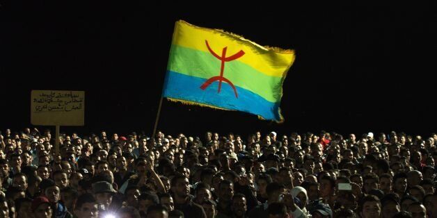Protesters hold the Amazigh (Berber) flag as they shout slogans in the northern city of Al Hoceima on October 30, 2016, following the death of fishmonger Mouhcine Fikri, who was crushed to death on October 28 in a rubbish truck in Al Hoceima, as he reportedly tried to protest against a municipal worker seizing and destroying his wares. Thousands of Moroccans on October 30 attended the funeral of the fishmonger whose gruesome death in a rubbish truck crusher has caused outrage across the North African country. An image of his inert body -- head and arm sticking out from under the lorry's crushing mechanism -- went viral on social media, sparking calls for protests nationwide including in the capital Rabat. / AFP / FADEL SENNA (Photo credit should read FADEL SENNA/AFP/Getty Images)