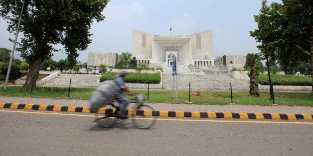A man rides a bicycle past the Supreme Court building in Islamabad, Pakistan, June 27, 2016. Picture taken June 27, 2016. To match Insight PAKISTAN-MILITARY/COURTS REUTERS/Faisal Mahmood