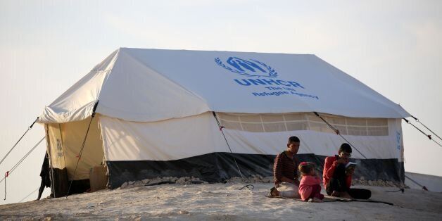 Youth sit outside a UNHCR tent at a refugee camp housing Iraqi families who fled fighting in the Mosul area on October 17, 2016 in the northeastern town of al-Hol in Syria's Hasakeh province. The battle to retake the Iraqi city of Mosul from jihadists could unleash a massive humanitarian crisis, potentially pushing hundreds of thousands to flee their homes as winter sets in. / AFP / DELIL SOULEIMAN (Photo credit should read DELIL SOULEIMAN/AFP/Getty Images)