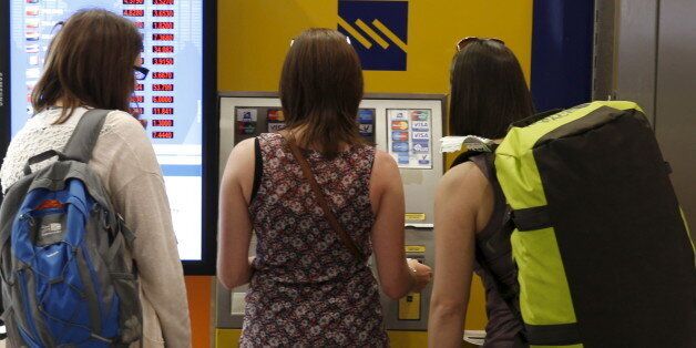 Tourists line up at an ATM at Athens international airport upon their arrival in Greece June 29, 2015. Greece closed its banks and imposed capital controls on Sunday to check the growing strains on its crippled financial system, bringing the prospect of being forced out of the euro into plain sight. REUTERS/Marko Djurica