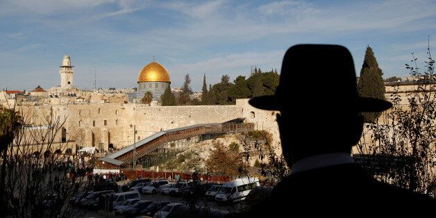 An ultra-Orthodox Jewish man stands at a view-point overlooking a wooden ramp (C) leading up from Judaism's Western Wall to the sacred compound known to Muslims as the Noble Sanctuary and to Jews as Temple Mount, where the al-Aqsa mosque and the Dome of the Rock shrine stand, in Jerusalem's Old City December 12, 2011. REUTERS/Ronen Zvulun/File Photo