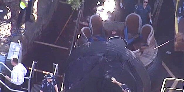 In this image made from video, rescue personnel stand by the Thunder River Rapids ride at Dreamworld on the Gold Coast, Australia, Tuesday, Oct. 25, 2016. Four people died after a malfunction caused two people to be ejected from their raft, while two others were caught inside the ride at the popular theme park on Australia's east coast. (Channel 9 via AP)