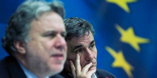 Greek Finance Minister Euclid Tsakalotos, right, listens as Labour Minister George Katrougalos talks during a news conference in Athens, on Tuesday, April 12, 2016. Greece and bailout creditors have suspended talks on the countryâs austerity program until next week, but Athens promised to submit a major new round of cost-cutting reforms to be voted by parliament by the end of the month.(AP Photo/Petros Giannakouris)