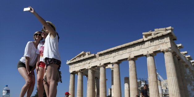 A group of tourists take a selfie in front of the temple of the Parthenon atop the Acropolis in Athens, Greece July 9, 2015. A race to save Greece from bankruptcy and keep it in the euro gathered pace on Wednesday when Athens formally applied for a three-year loan and European authorities launched an accelerated review of the request. REUTERS/Christian Hartmann