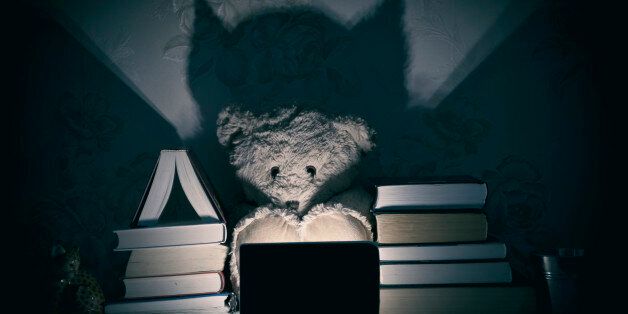 Scared Teddy Bear in front of digital device with his shadow as monster