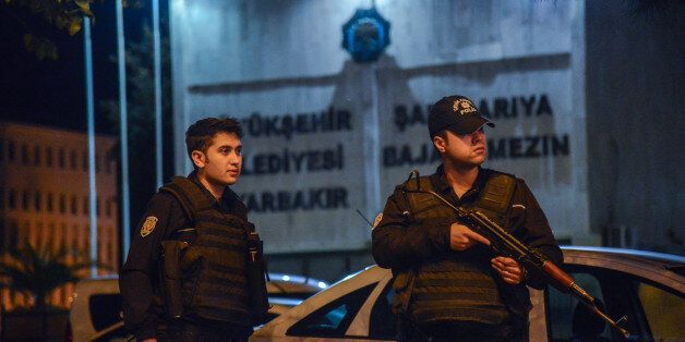 Armed Turkish anti riot police officers stand in front of the Diyarbakir's municipality headquarters on October 25, 2016 in Diyarbakir. The two co-mayors of Diyarbakir, the biggest Kurdish-majority city in southeast Turkey, have been arrested as part of a 'terrorism' enquiry, security officials said. There was a heavy police presence around the town hall following the arrests of Gultan Kisanak and Firat Anli, who together lead a city that has been rocked by clashes between security forces and members of the outlawed Kurdistan Workers' Party (PKK). / AFP / ILYAS AKENGIN (Photo credit should read ILYAS AKENGIN/AFP/Getty Images)