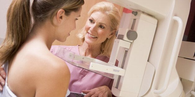 Nurse Assisting Patient Undergoing Mammogram Smiling
