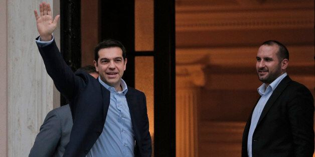 Greece's Prime Minister Alexis Tsipras waves to the members of media as he arrives at Maximos Mansion, the Greek Prime Minister's official residence in Athens, Monday, Jan. 26, 2015. Dimitris Tzanakopoulos, right, the newly-appointed chief of staff of Tsipras, looks on. Radical left leader Alexis Tsipras has been sworn in as Greece's new prime minister, becoming the youngest man to hold the post in 150 years. (AP Photo/Lefteris Pitarakis)
