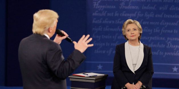 Democratic presidential nominee Hillary Clinton listens to Republican presidential nominee Donald Trump during the second presidential debate at Washington University, Sunday, Oct. 9, 2016, in St. Louis. (AP Photo/John Locher)