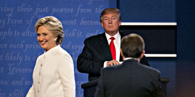 Donald Trump, 2016 Republican presidential candidate, stands as Hillary Clinton, 2016 Democratic presidential candidate, exits the stage after the third presidential debate in Las Vegas, Nevada, U.S., on Wednesday, Oct. 19, 2016. Donald Trump is trying another wild-card play in the third and final presidential debate with Hillary Clinton in perhaps his last chance to reverse his campaign's spiral and halt his Democratic rival's rising electoral strength. Photographer: Daniel Acker/Bloomberg via Getty Images