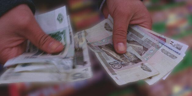 Russian currency: man's hand's holding roubles, close-up