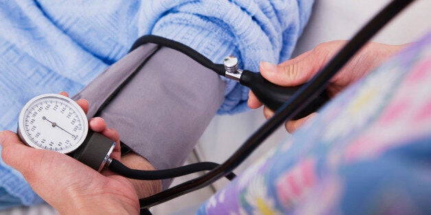 Close-up of female nurse taking senior woman's blood pressure