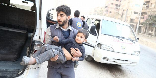A member of the Syrian Civil Defence, known as the White Helmets, evacuates a child following reported government shelling on the rebel-held town of Douma, east of the Syrian capital Damascus, on October 26, 2016. / AFP / Abd Doumany (Photo credit should read ABD DOUMANY/AFP/Getty Images)