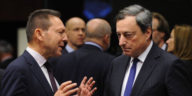 Greek Finance Minister Yannis Stournaras (L) speaks with European Central Bank (ECB) president Mario Draghi before a Eurogroup Council meeting at EU Headquarters in Brussels on December 17, 2013. AFP PHOTO/JOHN THYS (Photo credit should read JOHN THYS/AFP/Getty Images)