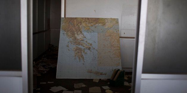 In this photo taken on Tuesday, May 19, 2015, a map of Greece lies inside what used to be airline offices at the abandoned former Athens International Airport, which shut down in 2001. (AP Photo/Petros Giannakouris)