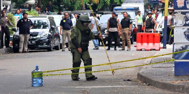 A member of police bomb squad inspects the site where police officers were attacked earlier, in Tangerang, Indonesia, Thursday, Oct. 20, 2016. A man with an Islamic State group symbol was shot Thursday after attacking the officers with a machete, police said. (AP Photo)