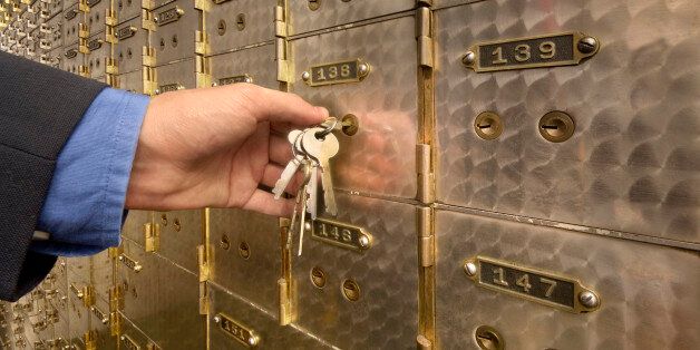 Man's hand holding key to safety deposit box, close-up
