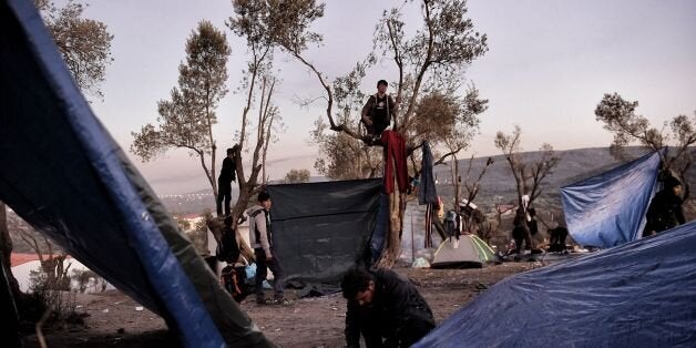 Refugees and migrants live at a field outside the Moria Hot Spot on the Greek Lesbos island on November 12, 2015. AFP PHOTO / ARIS MESSINIS (Photo credit should read ARIS MESSINIS/AFP/Getty Images)