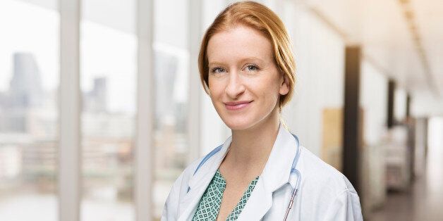 Portrait of female doctor in corridor in hospital.
