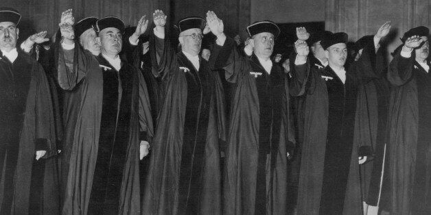 (GERMANY OUT) GERMANY: JUDGES, 1936. /nCeremony in criminal court at Berlin with judges displaying their loyalty to the Nazi Party (note party insignia on their robes), 1 October 1936. (Photo by ullstein bild/ullstein bild via Getty Images)