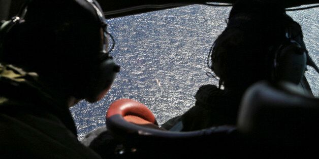 FILE - In this April 4, 2014, file photo, Wing Commander Rob Shearer, captain of the Royal New Zealand Air Force P3 Orion, left, and Sgt. Sean Donaldson look out the cockpit windows during search operations for missing Malaysia Airlines Flight MH370 in the southern Indian Ocean, near the coast of Western Australia. With the Friday, July 22, 2016, announcement that the meticulous ocean search operations for missing Malaysia Airlines Flight 370 would be suspended, the epic arc of one of this decade's most vexing unanswered questions is headed toward becoming, in effect, a cold case. (AP Photo/Nick Perry, File)