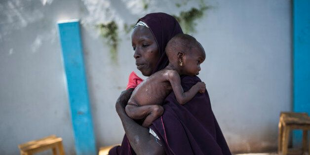 TOPSHOT - This photo taken on September 15, 2016 shows a mother holding her young malnourished baby at a public health facility in the Dalaram district of Maiduguri, northeast Nigeria. Aid agencies have long warned about the risk of food shortages in northeast Nigeria because of the conflict, which has killed at least 20,000 since 2009 and left more than 2.6 million homeless. In July, the United Nations said nearly 250,000 children under five could suffer from severe acute malnutrition this year