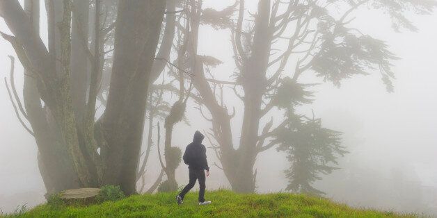 Man walking in Grand View Park on foggy day in San Francisco.