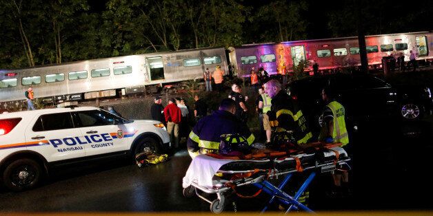 Emergency responders work near a train that sits derailed near the community of New Hyde Park on Long Island in New York, U.S, October 8, 2016. REUTERS/Eduardo Munoz