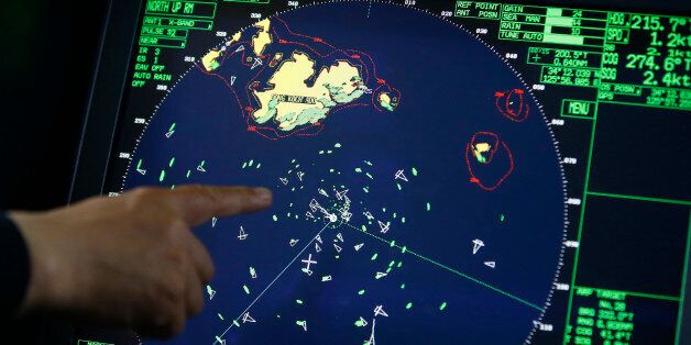 An official on a Coast Guard's rescue ship points out a radar displaying the area where South Korean passenger ship