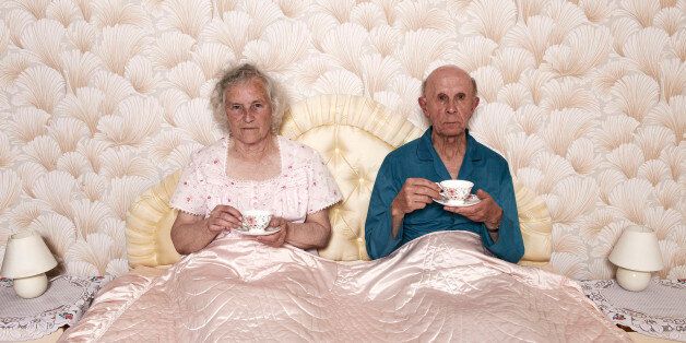 senior married pensioners aged two people dated retro sharing patterned chintz Caucasian wallpaper bedtime routine repetitive dotage long suffering husband wife male female man woman retired retirement resignation