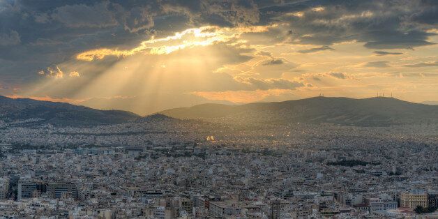 Rays of sunlight breaking through dramatic clouds over Athens, Greece