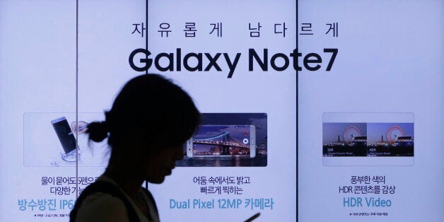 FILE - In this Friday, Sept. 2, 2016, file photo, a woman walks by an advertisement of the Samsung Electronics Galaxy Note 7 smartphone at the company's showroom in Seoul, South Korea. Samsung is asking owners of its fire-prone Galaxy Note 7 to do something crazy: âpower down and stop using the device.â This is all but unthinkable in an age where smartphones have become an extra limb, the last thing we look at before falling asleep and the first thing we grab in the morning, not to mention throughout the day. (AP Photo/Ahn Young-joon, File)