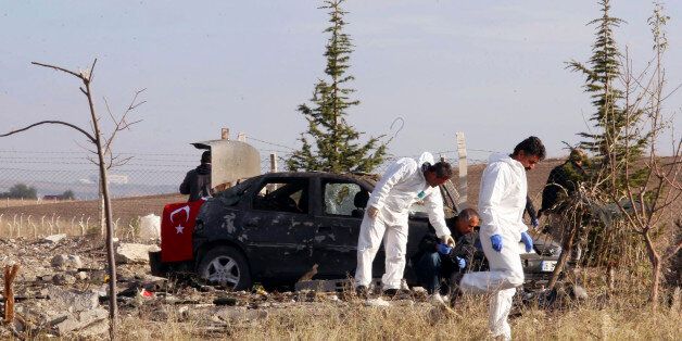 Police forensic officers work at the scene after suicide bombers blew themselves up in Haymana in the outskirts of Ankara, Turkey, Saturday, Oct. 8, 2016. A Turkish official says two suicide car bombers have blown themselves up after being stopped by police. Governor Erkan Topaca said the two bombers - a man and a woman - died in the incident Saturday outside a horse farm but no one else was hurt. (DHA via AP)