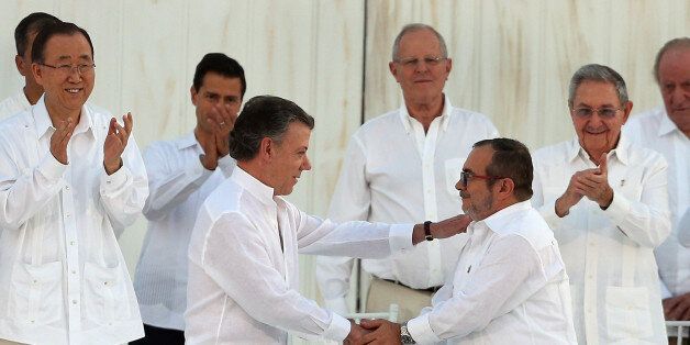 Colombiaâs President Juan Manuel Santos, front left, and the top commander of the Revolutionary Armed Forces of Colombia (FARC) Rodrigo Londono, known by the alias Timochenko, shake hands after signing the peace agreement between Colombiaâs government and the FARC to end over 50 years of conflict in Cartagena, Colombia, Monday, Sept. 26, 2016. (AP Photo/Fernando Vergara)