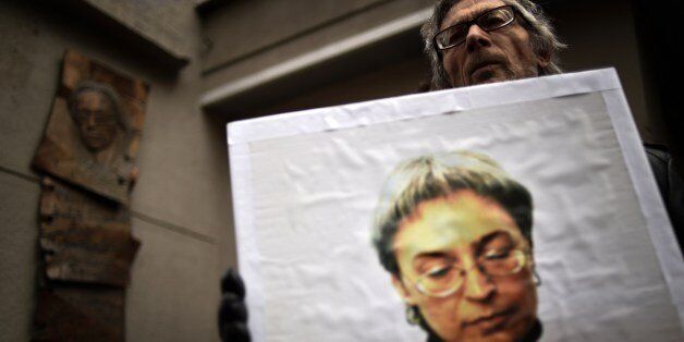 A man holds a portrait of slain Russian journalist Anna Politkovskaya during a rally marking the 8th anniversary of her death in Moscow on October 7, 2014. Politkovskaya was gunned down in Moscow in 2006. AFP PHOTO/KIRILL KUDRYAVTSEV (Photo credit should read KIRILL KUDRYAVTSEV/AFP/Getty Images)
