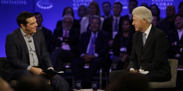 Prime Minister of Greece Alexis Tsipras (L) speaks with former President Bill Clinton during the Clinton Global Initiative annual meeting in New York on September 27, 2015. AFP PHOTO/JOSHUA LOTT (Photo credit should read Joshua LOTT/AFP/Getty Images)