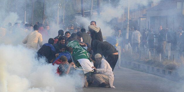 INDIA - 2016/10/08: People try to protect the dead body of 12 year old boy Junaid Ahmad after Indian police resorted to heavy teargas shelling in Srinagar the summer capital of Indian controlled Kashmir on October 08, 2016. Indian police resorted to intense teargas shelling on people in Eidgah area of Srinagar who were heading to bury the dead body of Ahmad. Junaid was shot dead after Indian police fired pellets in his head and chest without any provocation, local residents said. (Photo by Faisal Khan/Pacific Press/LightRocket via Getty Images)