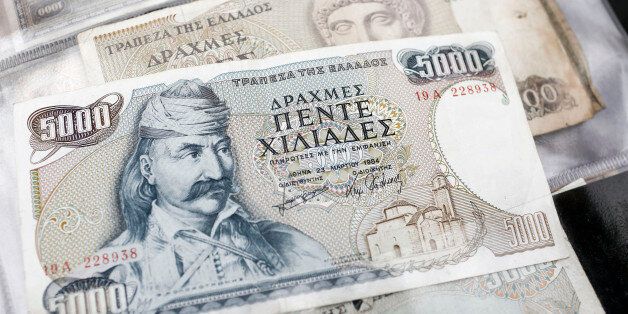 The image of Theodoros Kolokotronis, a Greek general and leader of the Greek War of Independence against the Ottoman empire, sits on an old Greek five thousand drachma banknote at it sits on display at a street vendors's stall at the Monastiraki flea market in Athens, Greece, on Saturday, July 11, 2015. European officials are grilling Greece on its bailout proposals in talks to save its place in the euro as a German-led bloc questions whether they go far enough. Photographer: Kostas Tsironis/Bloomberg via Getty Images