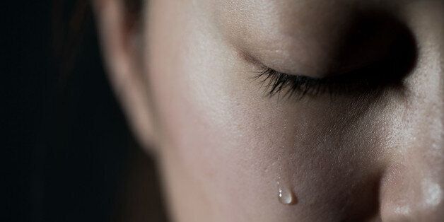 Young woman crying with tear drop.