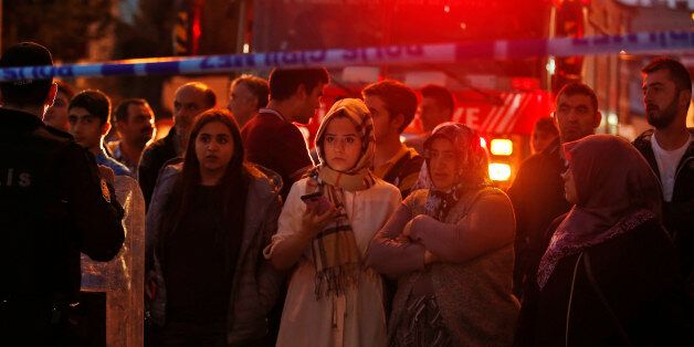 People watch behind a police line at the scene of a blast in Istanbul, Thursday, Oct. 6, 2016. A bomb placed on a motorcycle has exploded near a police station Thursday, wounding several people, Vasip Sahin, the governor for Istanbul, said. Turkish authorities have banned distribution of images relating to the explosion within Turkey. (AP Photo/Emrah Gurel)