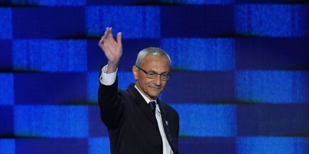 John Podesta, chair of the Hillary Clinton presidential campaign, waves as he arrives to speak during...