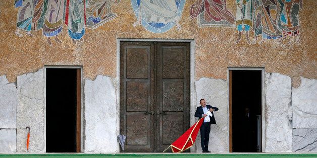 A man holds Montenegro's flag in front of the Serbian Orthodox Church of Christ's Resurrection in Podgorica, Montenegro, Saturday, Oct. 15, 2016. Montenegro's general election this weekend will decide whether the small Balkan state continues on a Western course, or becomes