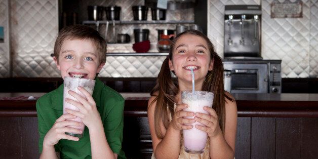 Boy and girl enjoying milkshakes