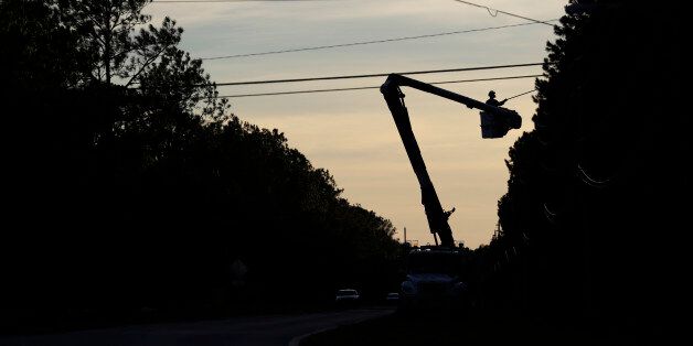 Crews remove limbs from power lines after winds from Hurricane Matthews hit the area, Saturday, Oct. 8, 2016, in Flagler Beach, Fla. Thousands of residents and businesses are with out power. (AP Photo/Eric Gay)