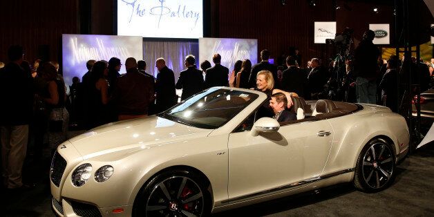 Attendees Debbie and Walker Bagby sit inside a Bentley Continental GT V8 S convertible automobile, produced by Bentley Motors Ltd., as it stands on display during The Gallery event at the MGM Grand Detroit ahead of the 2015 North American International Auto Show (NAIAS) in Detroit, Michigan, U.S., on Saturday, Jan. 10, 2015. NAIAS is expecting approximately 40-50 global and North American vehicle reveals during the Jan. 12-13 press preview for the show. Photographer: Jeff Kowalsky/Bloomberg via Getty Images