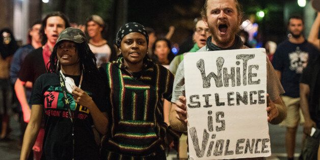CHARLOTTE, NC - SEPTEMBER 22: Demonstrators march together in protest on September 22, 2016 in Charlotte, NC. Protests began on Tuesday night following the fatal shooting of 43-year-old Keith Lamont Scott at an apartment complex near UNC Charlotte. A state of emergency was declared overnight in Charlotte and a midnight curfew was imposed by mayor Jennifer Roberts, to be lifted at 6 a.m. (Photo by Sean Rayford/Getty Images)