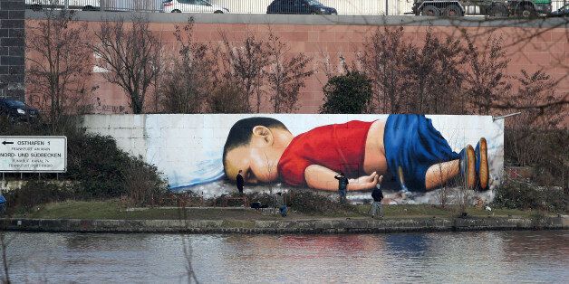 A graffiti by artists Justus Becker and Oguz Sen depicts the drowned Syrian refugee boy Alan Kurdi (initially reported as Aylan Kurdi) at the harbor in Frankfurt am Main, Germany, on March 10, 2016. / AFP / DANIEL ROLAND / RESTRICTED TO EDITORIAL USE - MANDATORY MENTION OF THE ARTIST UPON PUBLICATION - TO ILLUSTRATE THE EVENT AS SPECIFIED IN THE CAPTION (Photo credit should read DANIEL ROLAND/AFP/Getty Images)
