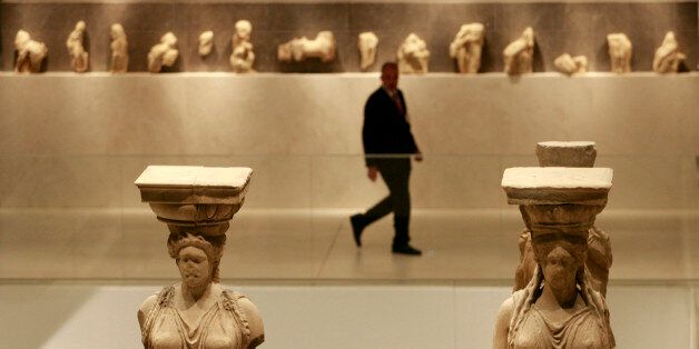 A security guard walks past Caryatid statues during the official opening ceremony of the New Acropolis Museum in Athens, June 20, 2009. Greece opened the gates of the long-awaited Acropolis Museum on Saturday, hoping the modern glass and concrete building will help bring back the Classical Parthenon sculptures from Britain. REUTERS/John Kolesidis (GREECE POLITICS SOCIETY)